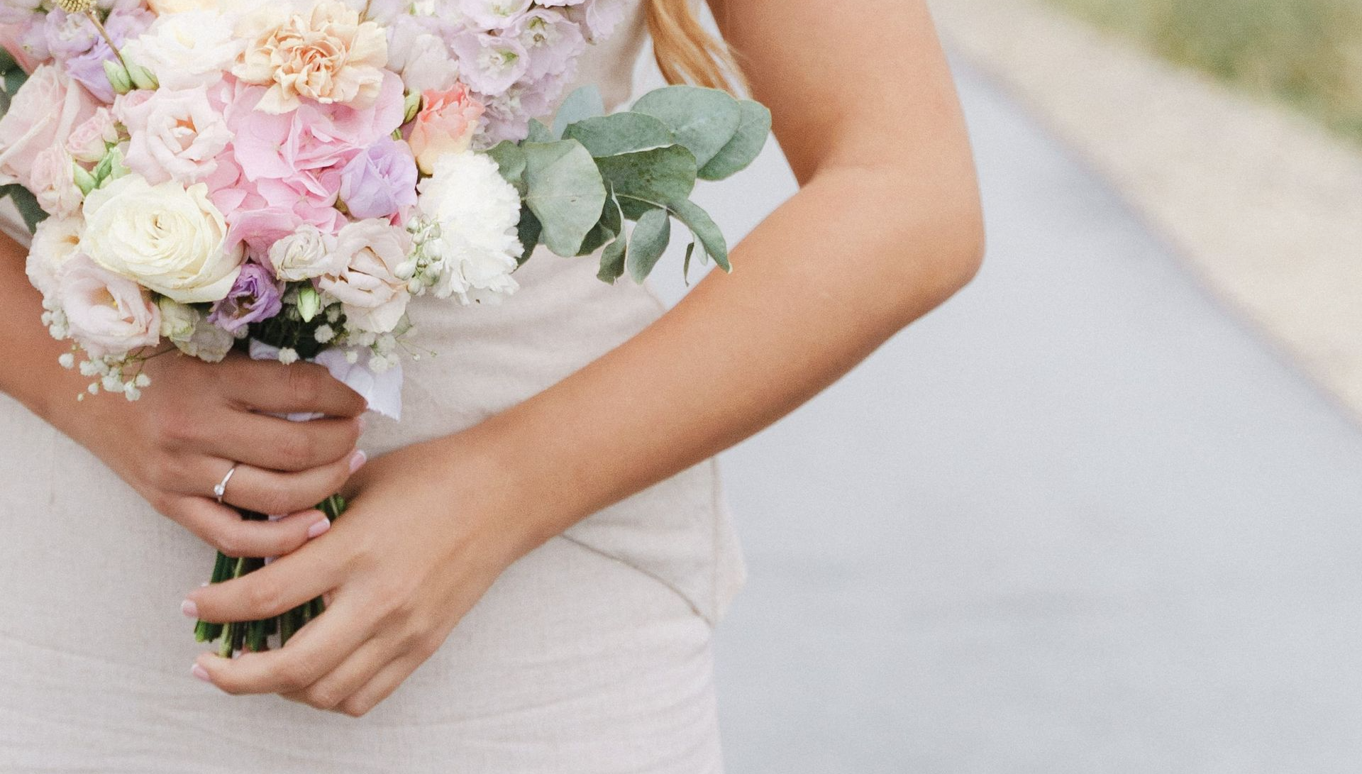 Bride holding a wedding bouquet of pastel colours.
