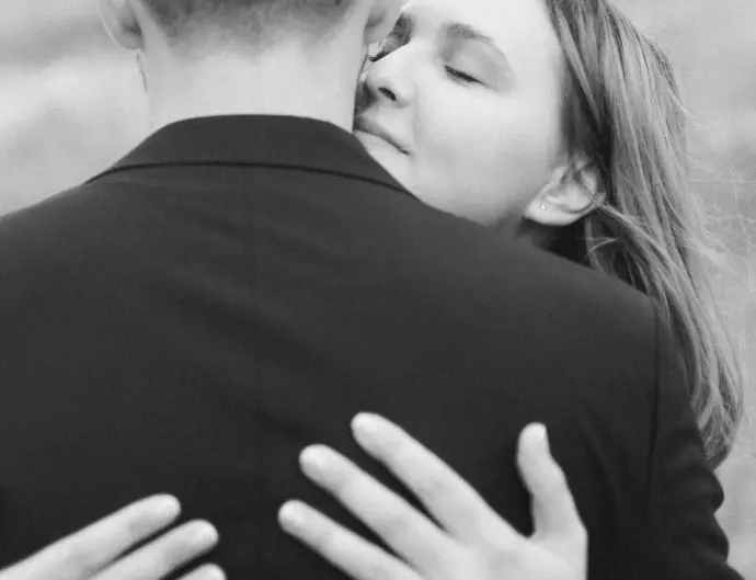 Black and white wedding portrait of a bride hugging her groom.